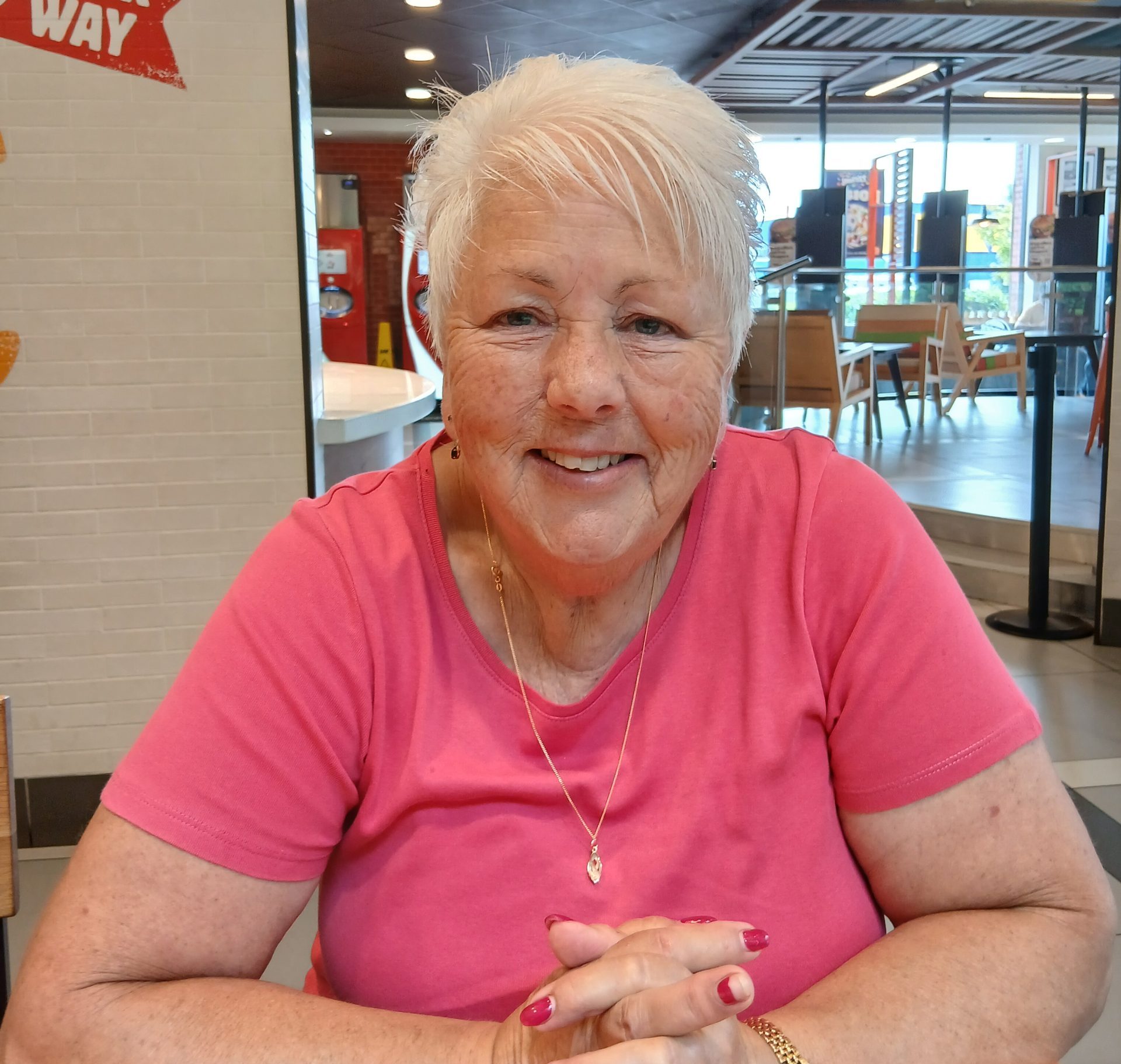 Liz sits smiling looking at the camera